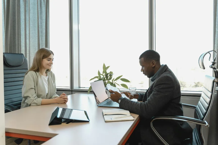 Asesoría entre una profesional y su cliente en una sala de reuniones